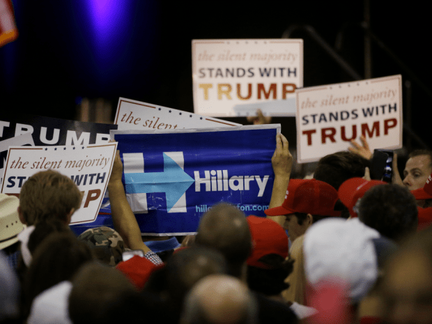 A woman holds up a sign for Democratic presidential candidate Hillary Clinton during a rally for Republican presidential candidate Donald Trump. AP Photo/Jae C. Hong.